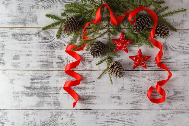 雪とスプルースの枝の赤いクリスマスの装飾