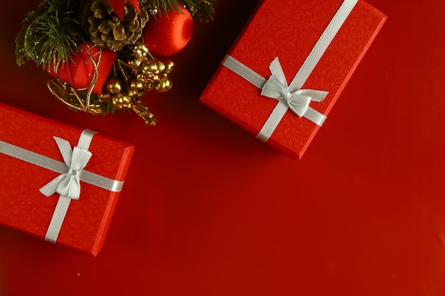 Premium Photo | Red christmas gift box with ornaments and red background.