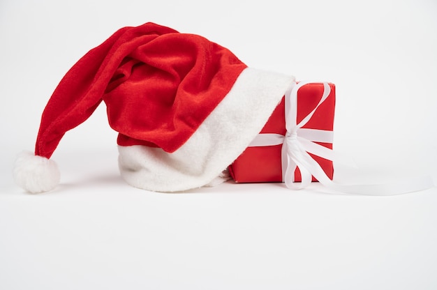 Confezione regalo di natale rosso con cappello santa isolato su bianco. foto di alta qualità