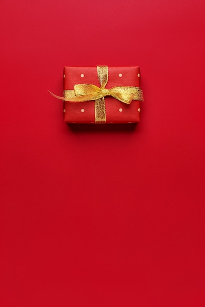 Red Christmas gift on red background with copy space.