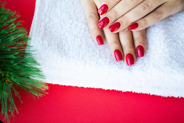 Red Christmas manicure maken in schoonheidsstudio op Kerstmis achtergrond.