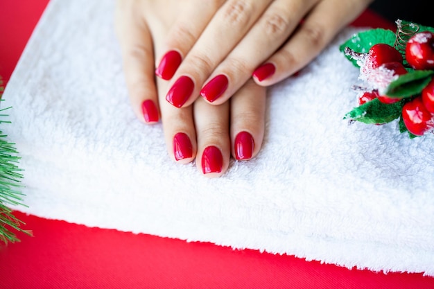 Red Christmas manicure maken in schoonheidsstudio op Kerstmis achtergrond.