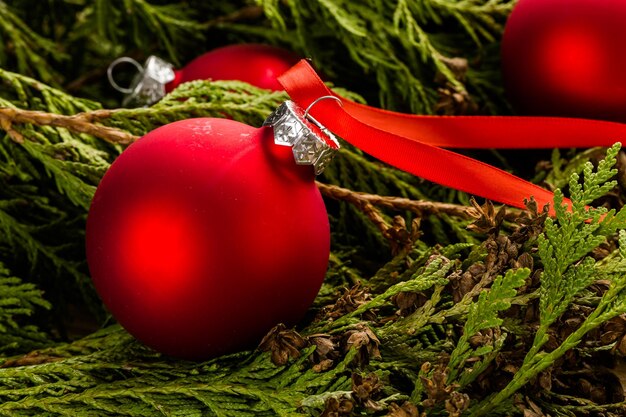 Red Christmas ornaments on stained wood table.