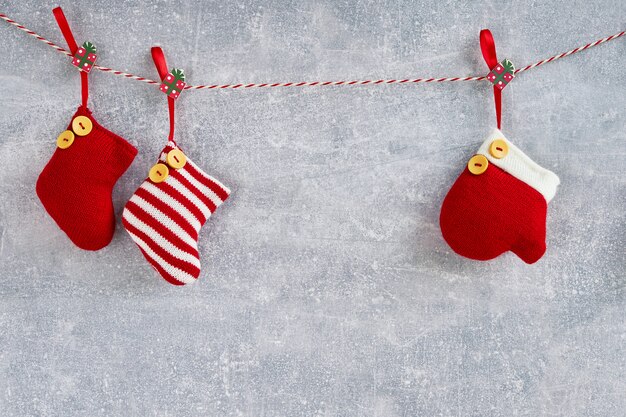 Red Christmas socks and mitten on gray. Copy space.