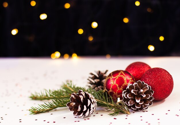 빨간 크리스마스 장난감과 소나무 콘은 bokeh와 흰색 배경에 거짓말