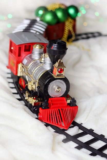 Red Christmas train on a light background, vertical photo