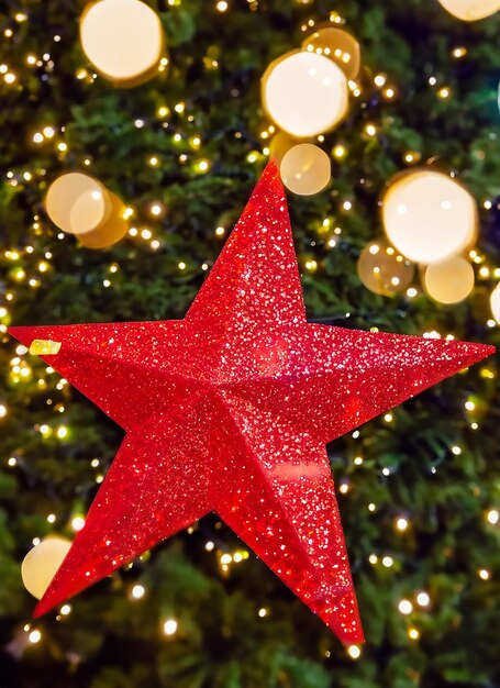 Photo red christmas tree star with bokeh lights in city