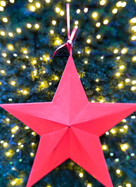 Foto stella rossa dell'albero di natale con luci bokeh in città