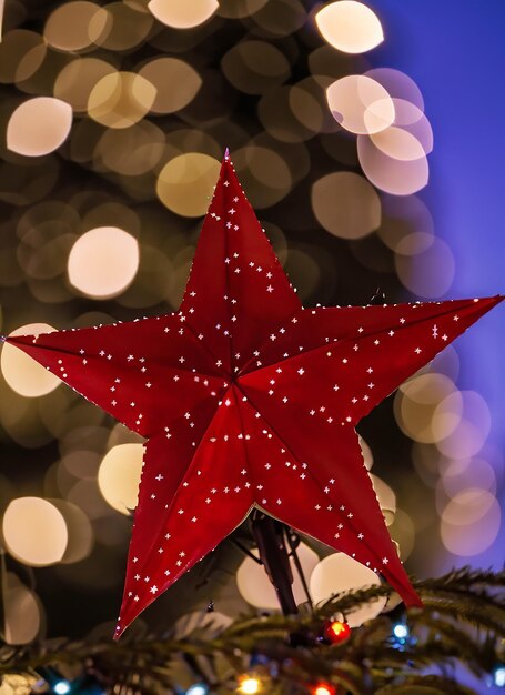 Foto stella rossa dell'albero di natale con luci bokeh in città