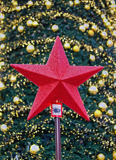 Фото Красная звезда рождественской елки с огнями боке в городе