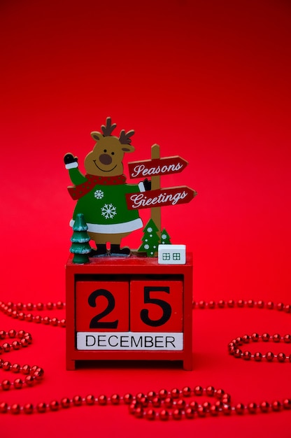 Red Christmas wooden calendar with a deer on a red background Date December 25