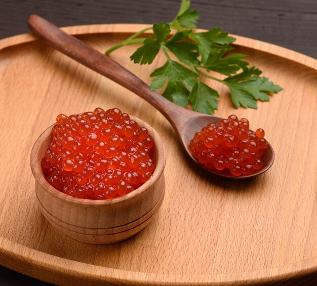 Red chum salmon caviar in a wooden bowl, delicious and healthy food, close up