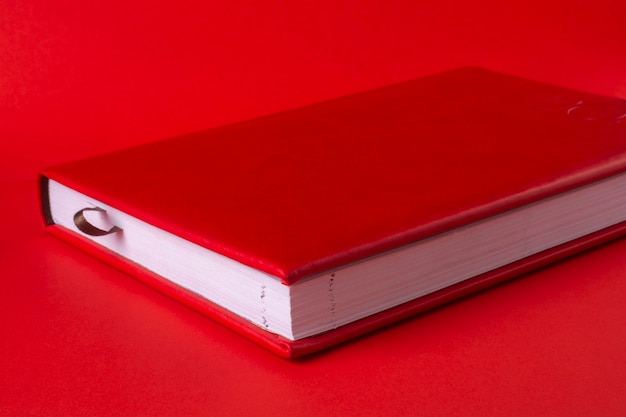 Red closed notepad on a red background