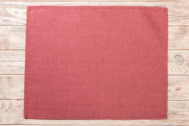 Red cloth napkin on brown rustic wooden 