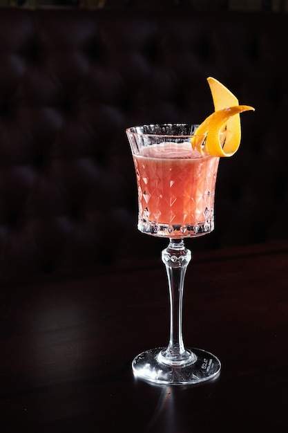 Red cocktail at bar in nightclub party. Cocktail on black background in glass glasses.