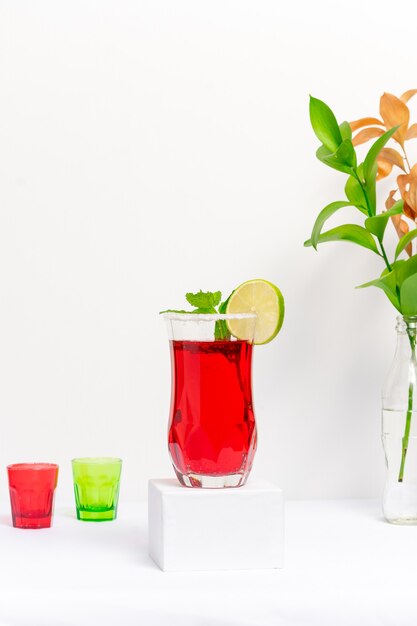 Red cocktail glass made of vodka and sparkling wine on white background