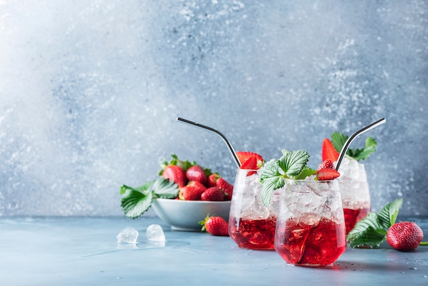 Red cocktail with ice and fresh strawberry