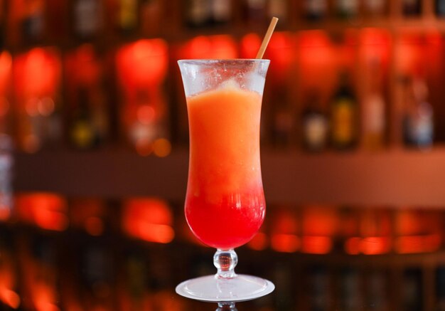 A red cocktail with a straw in it