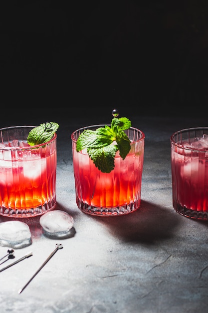 Red cocktails with cranberry, mint leaves and ice cubes