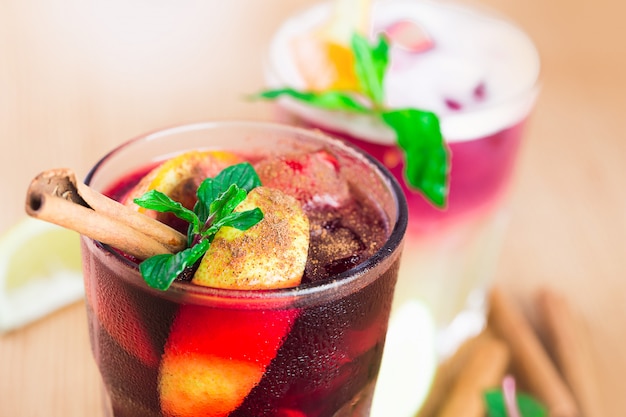 Red cocktails with mint, ice and cinnamon close up at a bar