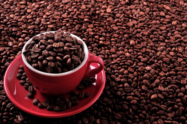 Red coffee cup filled with roasted beans