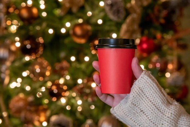 クリスマス ツリーの前に赤いコーヒー カップ