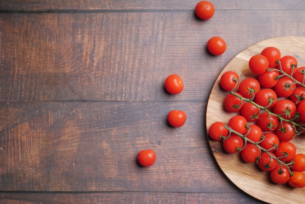 Red color cherry tomato on chopping board with copy space