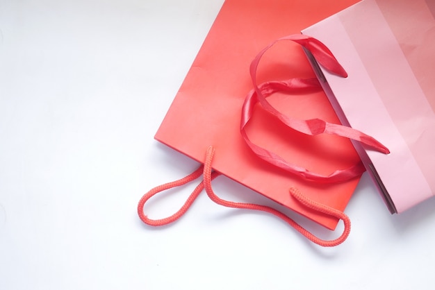 Red color gift bag on white surface top view