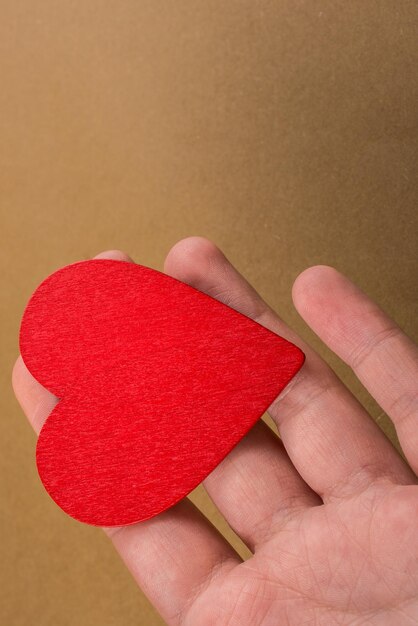 Red color heart shaped object in hand