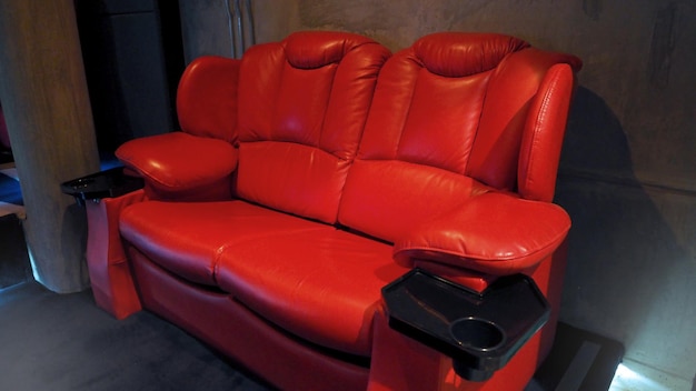 Red color leather movie theater cinema seat chairs which small and old dirty and very bad stingy smell