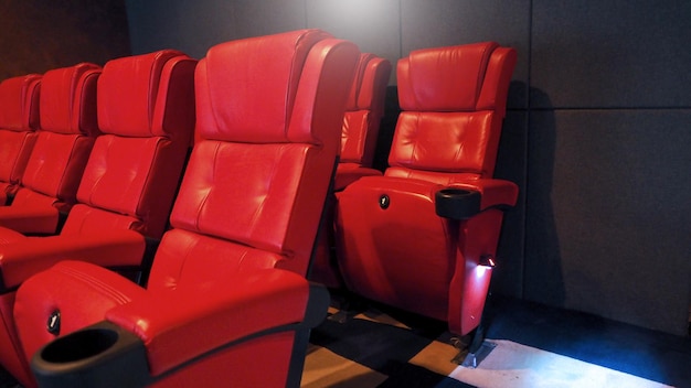 Red color leather movie theater cinema seat chairs which small and old dirty and very bad stingy smell