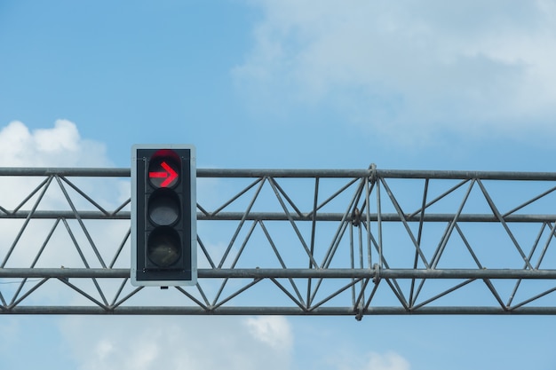 Красный цвет повернуть налево на светофоре с фоном голубого неба