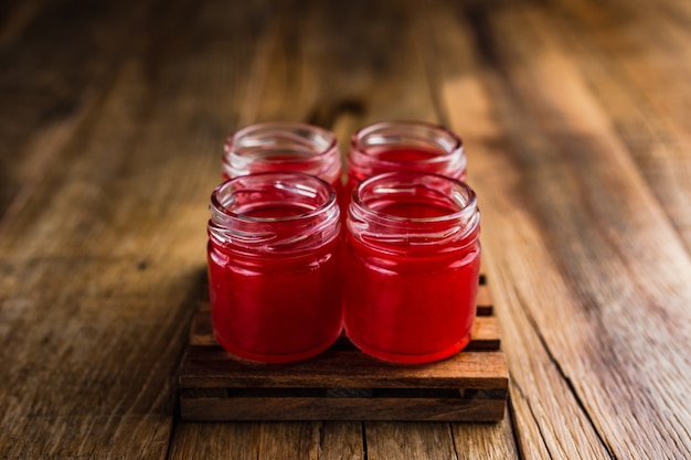 Red colored alcoholic shooters, or shot drinks on wooden table