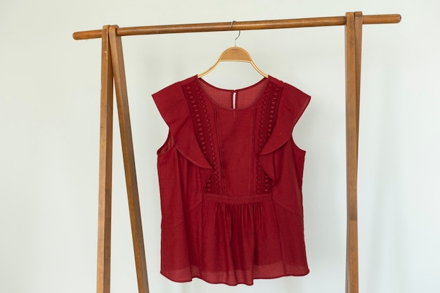 Red colour blouse is clothes hanger on white background