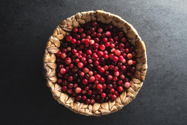 Red cranberries in a basket on a gray stone