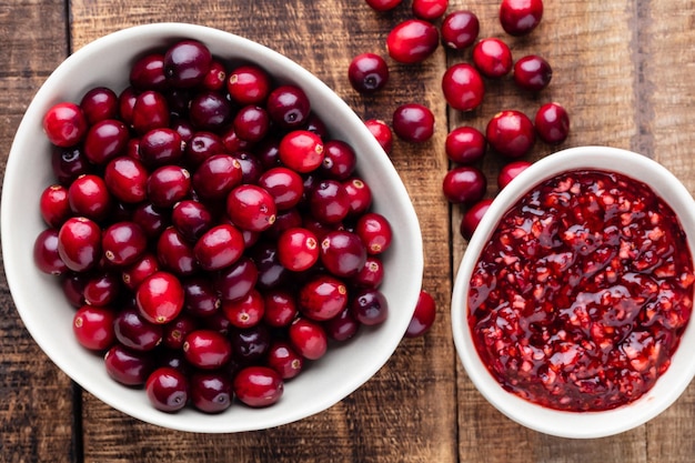 Red cranberries on wooden background Brries in a bowl