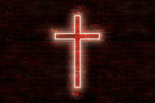 A red cross on a brick wall is lit up with the word jesus.