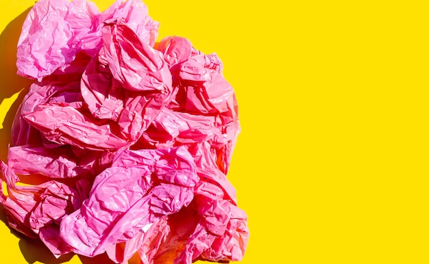 Red crumpled plastic bags on yellow surface