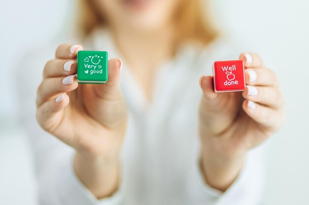 두 개의 큐브를 들고 있는 아주 좋은 소녀라는 비문이 있는 녹색 큐브가 잘 된 빨간색 큐브