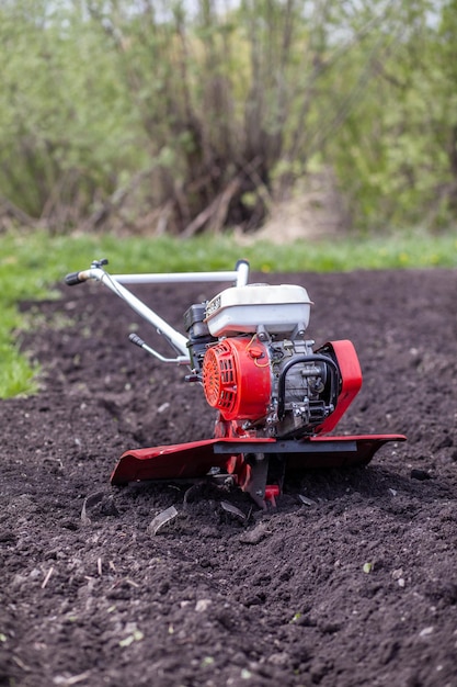 Red cultivator cultivates a vegetable garden for planting vegetables and potatoes