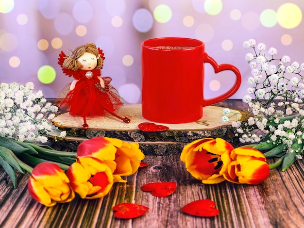 Красная чашка кофе с сердечными тюльпанами и гипсофильной открыткой на День святого Валентина.