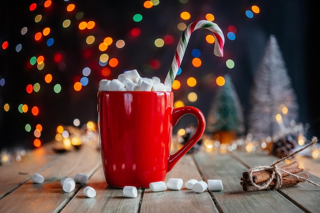 Red cup of hot chocolate with marshmallow on christmas background