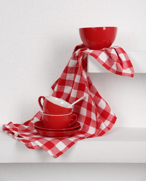 Red cups saucers and napkin on a white background