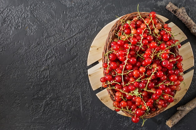 Red currant berries lying on gray  background with copy space