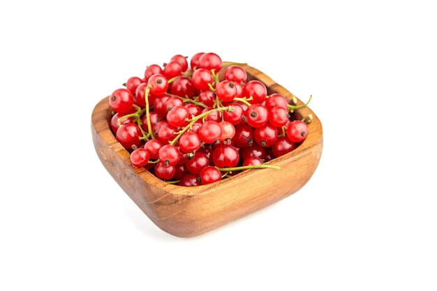 Red currant berries in wooden bowl isolated