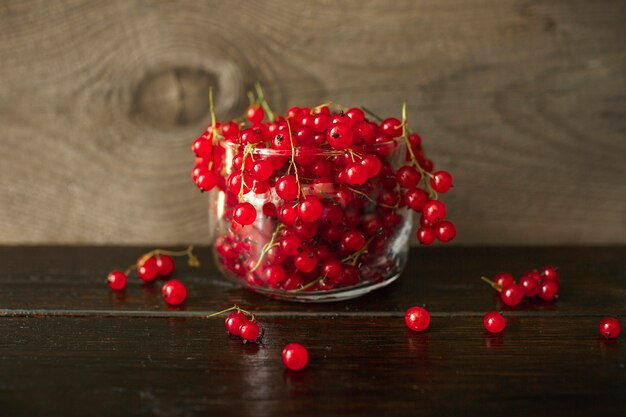 Red currant, berry on a wooden table, wooden background