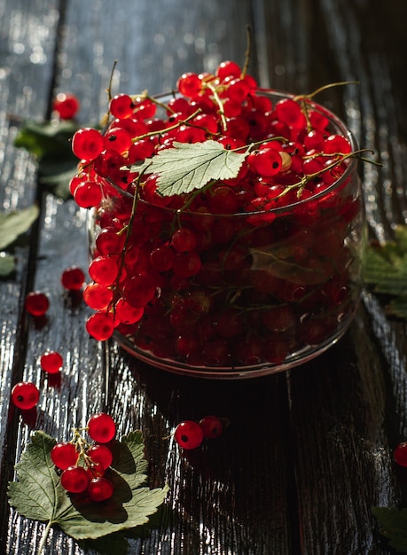 Red currant, berry on a wooden table, wooden background