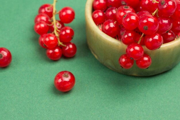 Red currants on green surface. Close up.