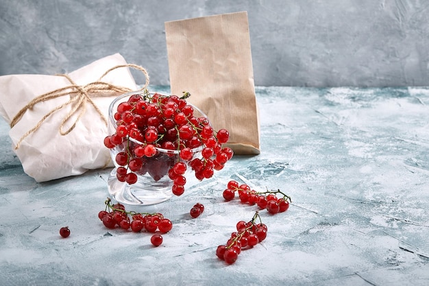 Foto ribes rosso in un piatto su uno sfondo chiaro concetto di consegna del cibo spazio per la copia dell'imballaggio ecologico