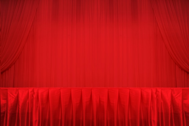 Red curtains and stage and table.